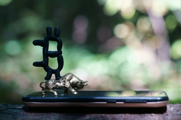 一个比特币雕像和一个手机上的金属公牛。图片下载