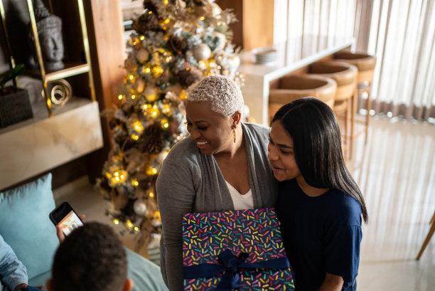 圣诞节妈妈和孩子在家里寻找手机照片图片下载