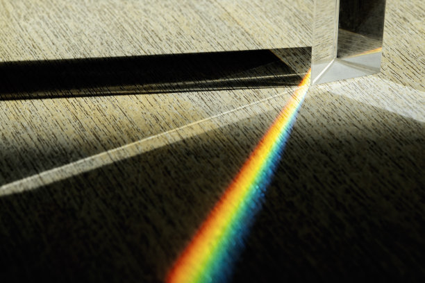 三角棱镜分散太阳光束分裂成光谱在木制背景上图片下载