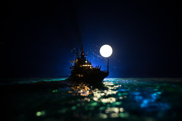 在雾蒙蒙的背景下，一群人站在模糊的军舰旁的剪影。有选择性的重点。图片下载