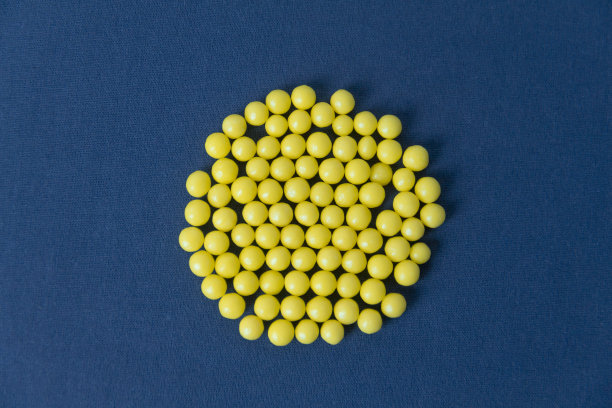黄色的小圆维生素排列成一个圈。图片下载