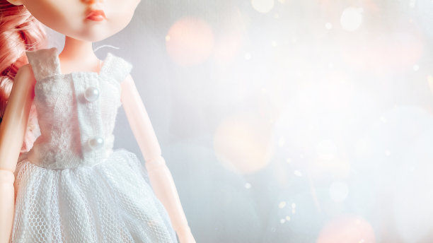 一个穿着白色连衣裙、头发是粉红色的娃娃站在神奇的散景背景下图片下载