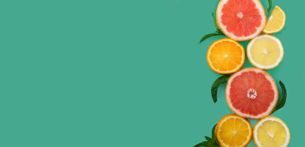 五颜六色的水果背景。平的。最小的食物设计创意与柑橘片框架薄荷布局。图片下载