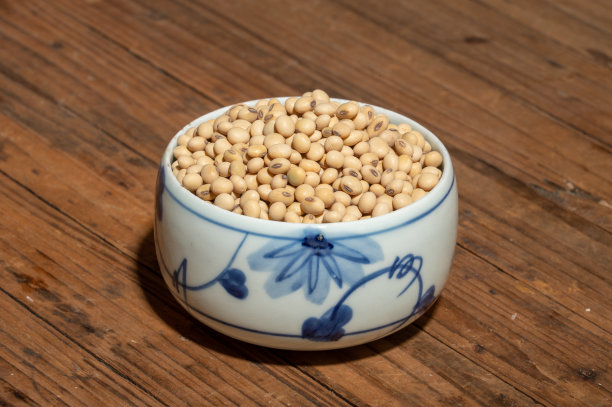木纹桌上放着碗或盘子里的大豆图片下载