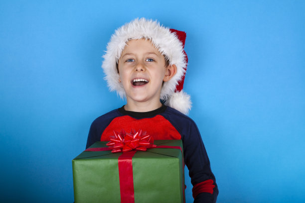 小男孩拿着大大的圣诞礼盒。图片下载