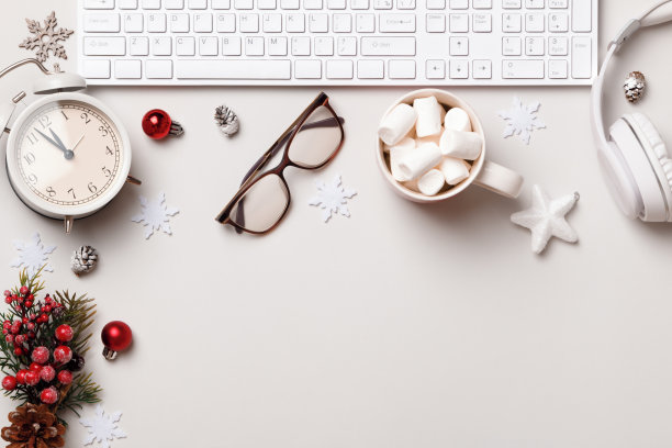 圣诞节的桌面。键盘眼镜耳机棉花糖闹钟在灰色的桌子上。平铺顶视图复制空间图片下载