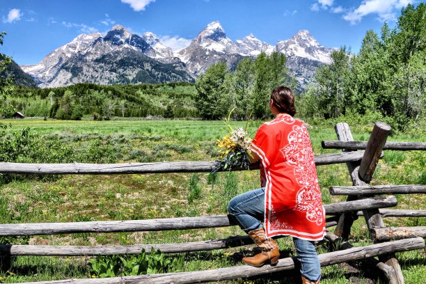 年轻女子从后面享受着庄严的提顿山脉的宁静之美-素材照片图片下载