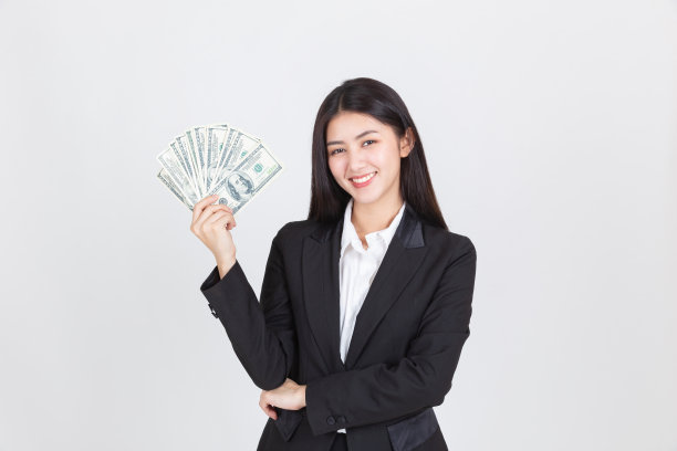 美丽的亚洲女人在黑色西装持有美元，交易和投资图片下载