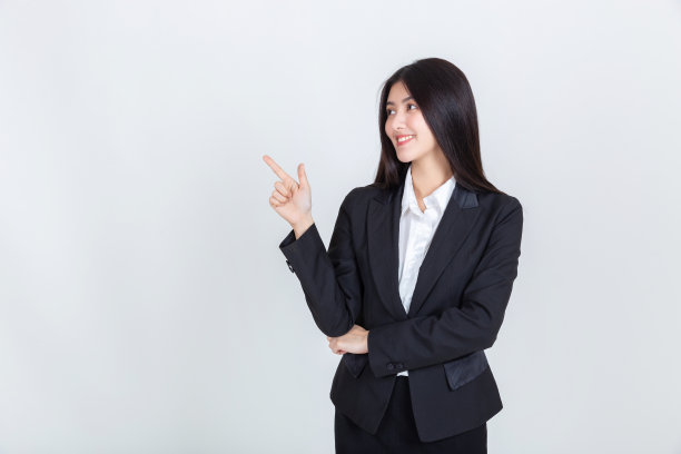 漂亮年轻的亚洲女商人的手指向复制空间为你的促销或文字在白色的背景。图片下载