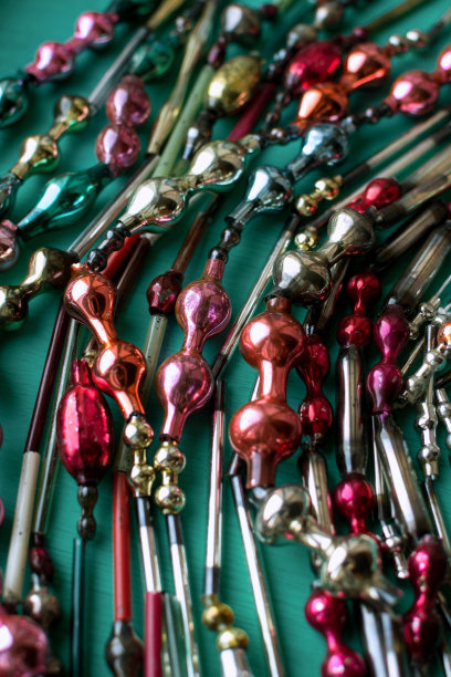 多色复古圣诞玻璃花环在绿色木制背景，节日装饰图片下载