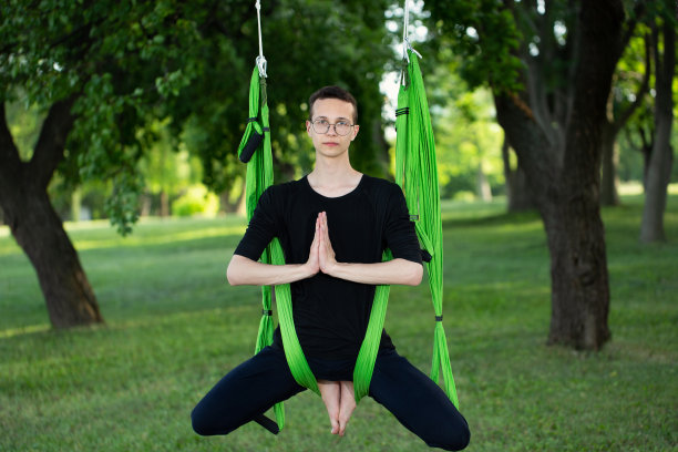 反重力瑜伽，一个男人在公园里做瑜伽图片下载