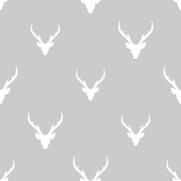 无缝冬季图案与白色剪影鹿头与鹿角。矢量平圣诞装饰品图片下载