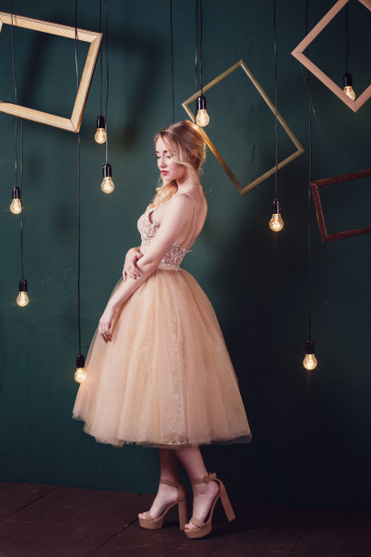 时尚工作室的照片，美丽的年轻女孩，棕色头发，穿着豪华的米色连衣裙，图片下载