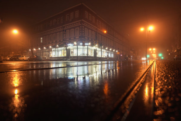 雾夜街道电车轨道和店面图片下载