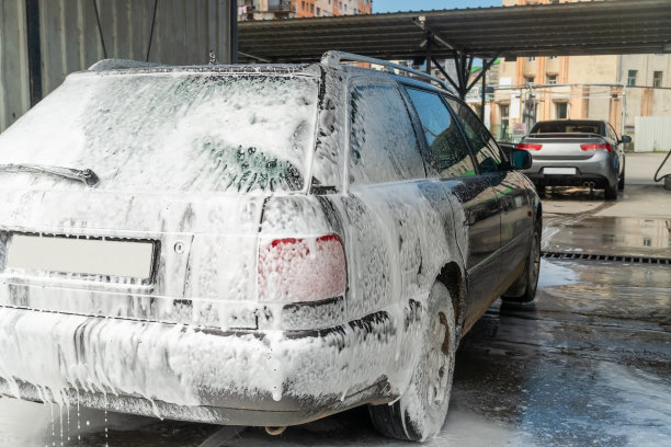 白色泡沫的灰色汽车在自助洗车图片下载
