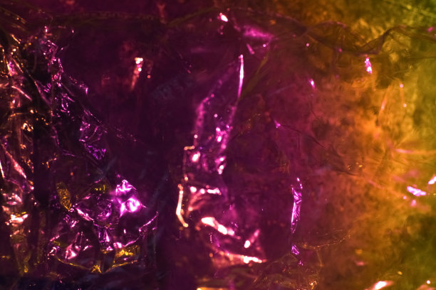 抽象的紫色彩色背景闪闪发光皱巴巴的全息图与火花。时尚的霓虹灯发光纹理背景。创意假日设计模板图片下载