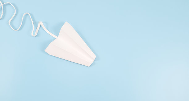 在蓝色背景上，左边有花边痕迹的白纸飞机图片下载