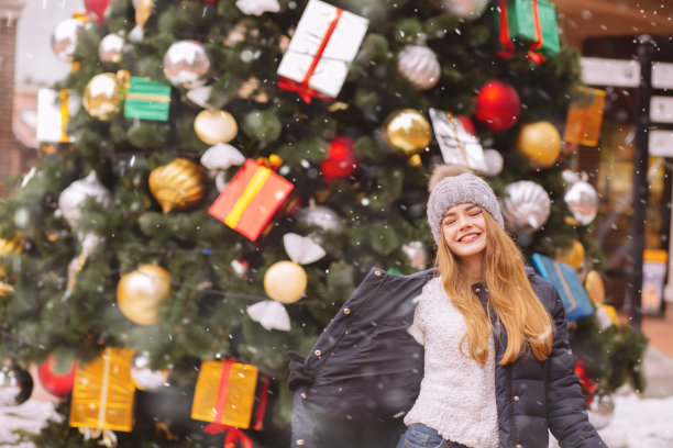 美丽的红发女士走在圣诞树附近图片下载