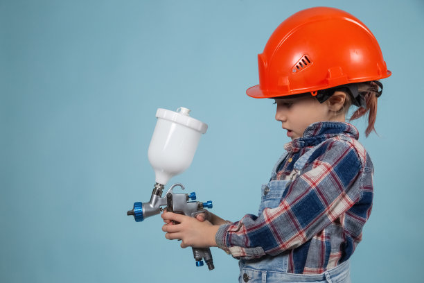 可爱的白人小孩戴着安全帽和电动喷枪图片下载