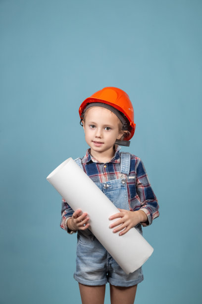 可爱的女孩建筑工人的肖像在安全帽持有施工图图片下载
