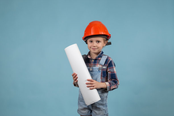 可爱的女孩建筑工人的肖像在安全帽持有施工图图片下载