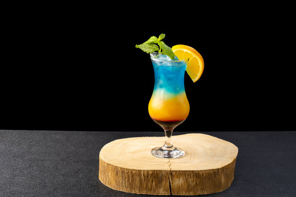 彩虹天堂鸡尾酒与三色库拉索蓝饮料，孤立在黑色的背景图片下载