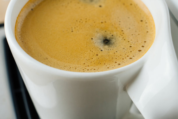 新鲜的浓缩咖啡与泡沫在白色杯子的近距离照片，从上面俯视图片下载