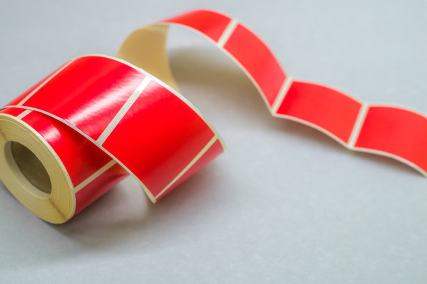 滚筒胶带红色不干胶标签。用于印刷和标记产品的材料。热标签。选择性聚焦，复制空间图片下载