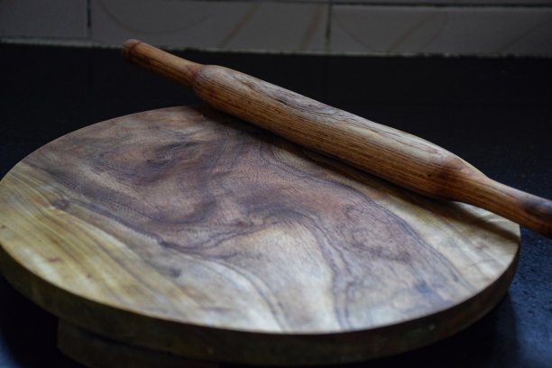 花岗岩厨房台面上木制擀面杖和圆形木板照片，印度卡纳塔克邦班加罗尔图片下载