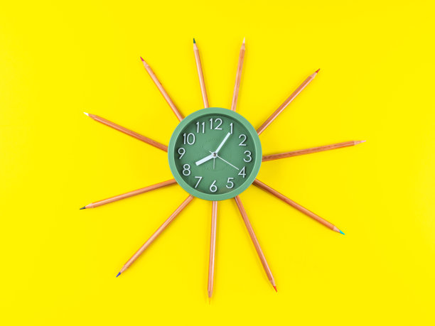 太阳形状的彩色蜡笔和闹钟图片下载