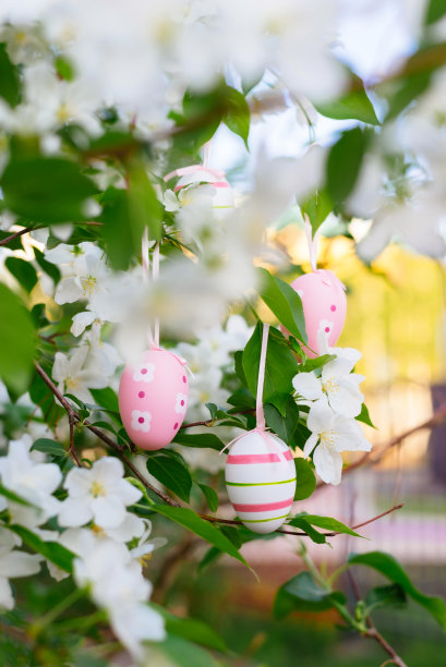 复活节粉红色的彩蛋在开花的树上。传统、节日、宗教观念。垂直的照片。图片下载