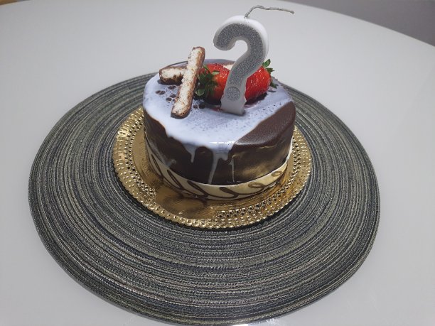 带巧克力糖衣和问号蜡烛的巧克力生日蛋糕。图片下载