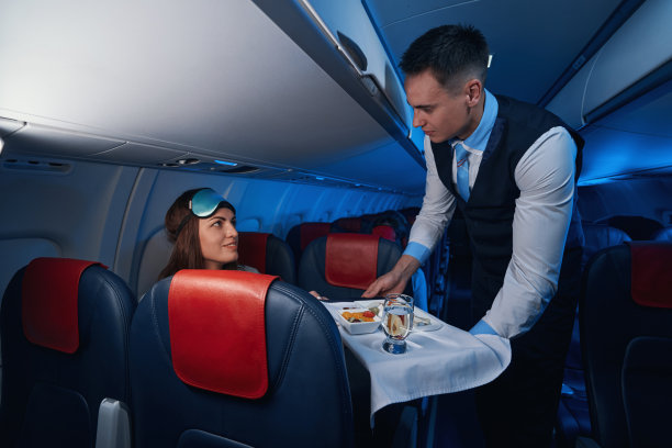 男空乘人员给女乘客送餐素材图片