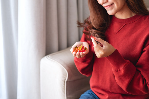 一个拿着并吃着小熊软糖的年轻女人图片下载