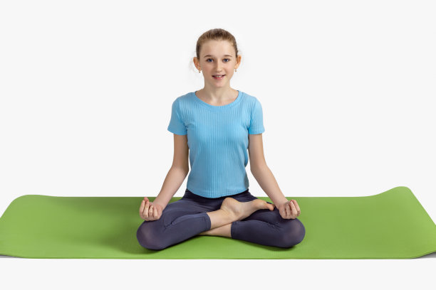 健康的生活方式。一个十几岁的女孩在绿色的地毯上练习瑜伽冥想。图片下载