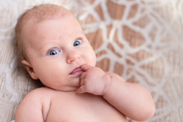 一个漂亮女婴的肖像躺在她房间的白色床单上图片下载