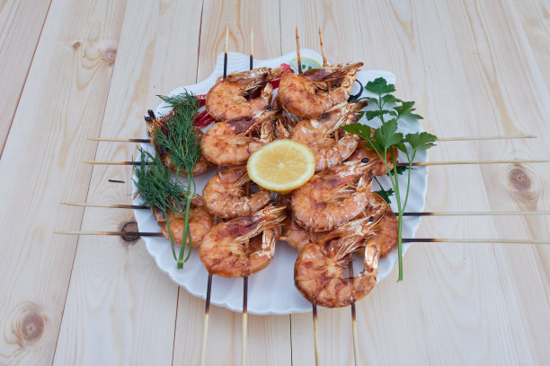 把炸虾放在木串上，放在盘子里。图片下载