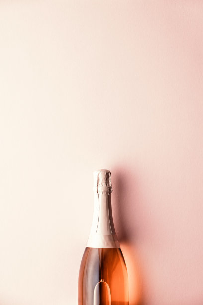 庆祝的平铺。粉色背景上的香槟瓶图片下载