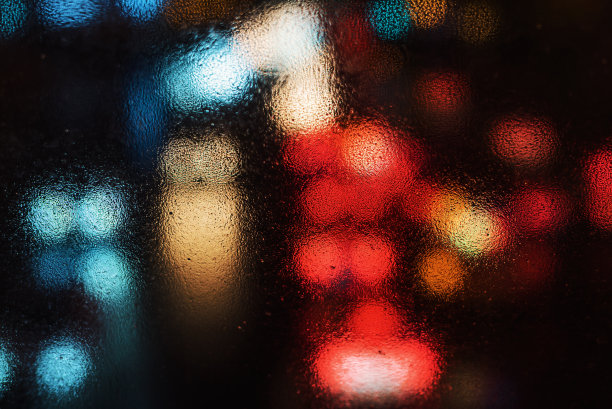 夜晚从潮湿的车窗后面传来的车流图片下载