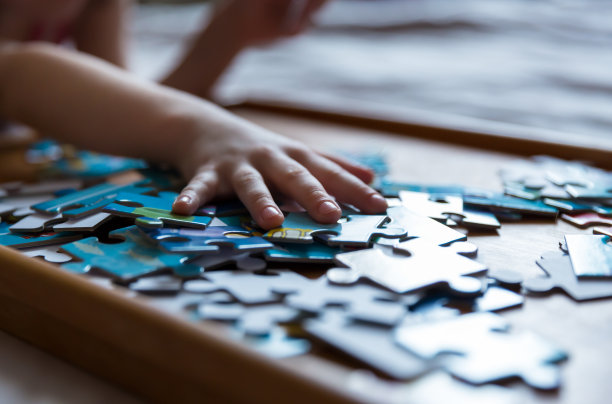 孩子们的手收集拼图。为孩子设计的教育游戏。图片下载