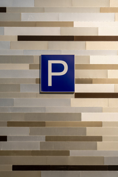 垂直照片的方形蓝色停车标志的汽车与字母P在一个棕色的墙壁上图片下载