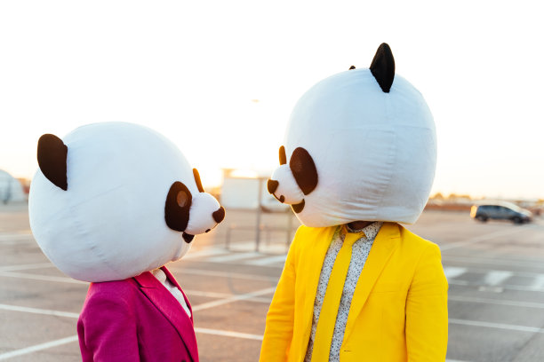 一对戴着大熊猫头的夫妇讲故事的形象图片下载