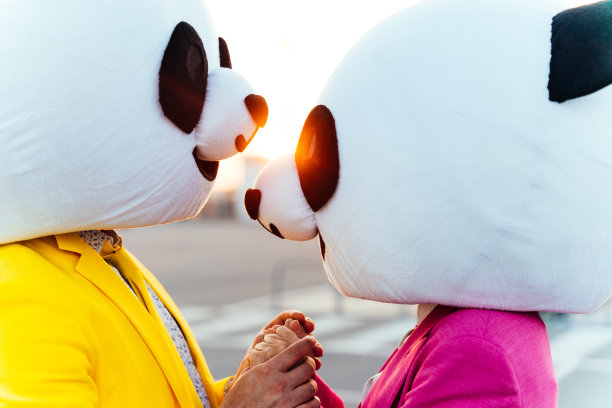一对戴着大熊猫头的夫妇讲故事的形象图片下载