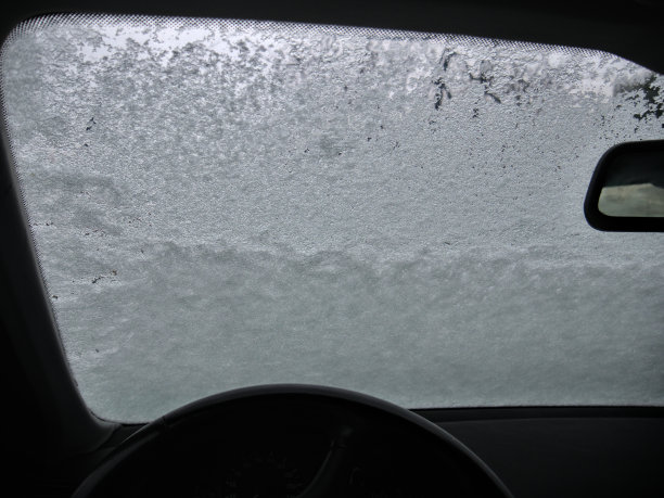 白雪覆盖的汽车挡风玻璃，从车厢内部看图片下载