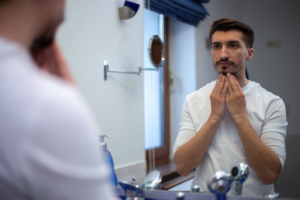 一个留着斑驳胡子的人看着镜子图片下载