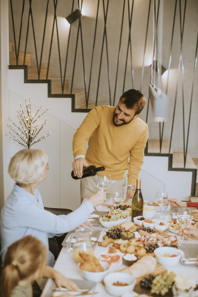 一个年轻人在家把红酒倒给他的母亲做测试图片下载