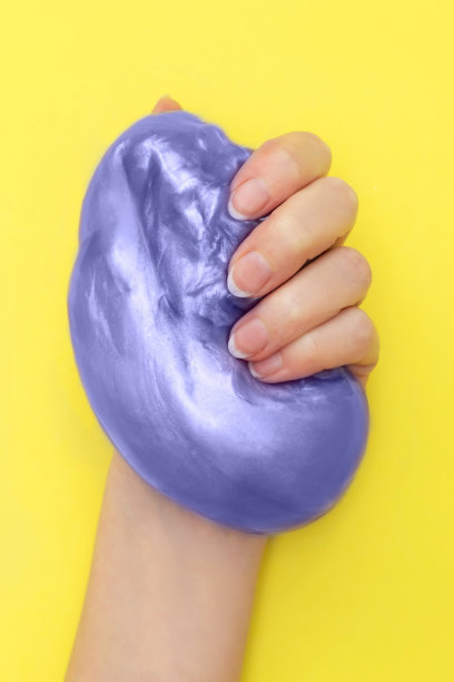 紫色黏液在手黄色。垂直的。图片下载