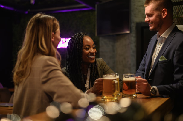 愉快的同事下班后一起在酒吧喝啤酒，玩平板电脑图片下载