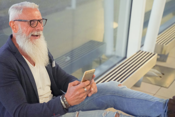 时尚男在国际机场使用智能手机。白人商人的肖像。成人微笑胡须时尚成功的商人企业家。旅行，旅行和工作概念。图片下载