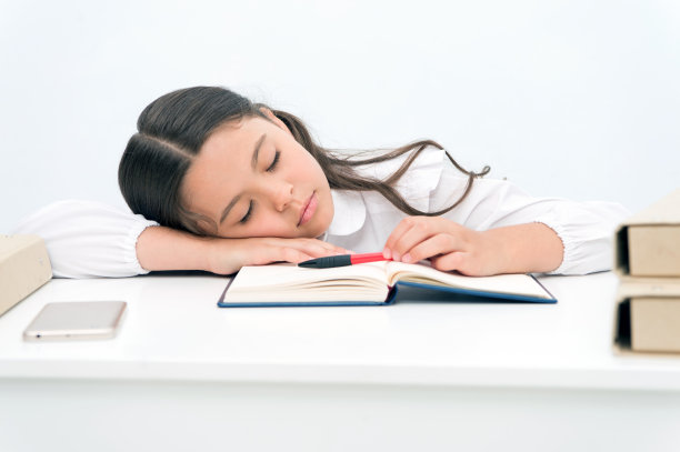 午睡的概念。疲惫的女学生午睡。小女孩在书桌前打盹。现在是午睡时间图片下载